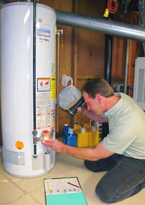 Plumber checks the eletrical panel of a 40 gallon storage water heater